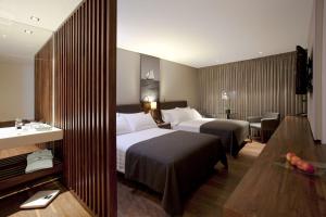 a hotel room with two beds and a table at Hotel Estelar Parque de la 93 in Bogotá