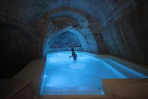 a person in a swimming pool in a tunnel at San Nicola Room e spa in Gravina in Puglia
