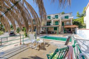a resort with a swimming pool and a building at Apartments Laguna in Stomorska