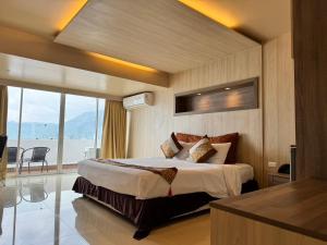 a bedroom with a large bed and a large window at Condo Minium Patong Phuket in Patong Beach
