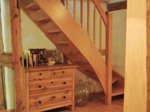a wooden staircase with a wooden dresser and a stair case at Chic Apartment in Thuringia with Sauna in Hamma