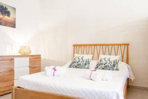 1 dormitorio con 1 cama blanca y 2 toallas blancas en Logement vue sur les oliviers, en Le Lamie di Olimpe