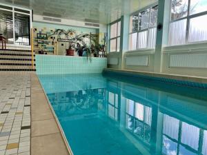a swimming pool in a building with blue tiles at Gemütliche Wohnung in Baiersbronn in Baiersbronn