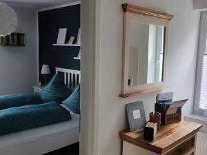 una camera da letto con un letto e uno specchio a parete di "On Lindenallee" a Bad Rothenfelde