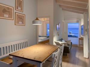 uma sala de jantar com uma mesa de madeira e uma sala com o oceano em House in reed 1 - apartment 4 em Neukieritzsch