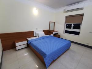 a bedroom with a blue bed and a window at Sóng Biển Hotel Cửa Lò in Cửa Lô