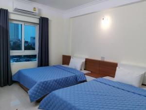 クアローにあるSóng Biển Hotel Cửa Lòのベッド2台と窓が備わるホテルルームです。