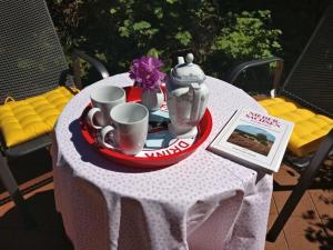 une table avec théière et tasses sur une assiette dans l'établissement Ahlers holiday apartment, à Schneverdingen