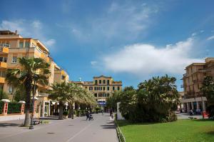 una calle en una ciudad con palmeras y edificios en Maremè Guest House Ostia, en Lido di Ostia