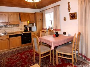 uma cozinha com uma mesa rosa e cadeiras num quarto em Holiday apartment Flora em Schönau am Königssee