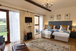 a bedroom with two beds and a large window at Brickfields Farm in Kirkbymoorside