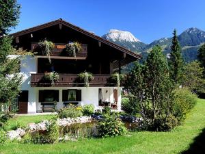 uma casa grande com montanhas ao fundo em Holiday apartment Flora em Schönau am Königssee