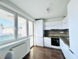 eine Küche mit weißen Schränken und einem Fenster in der Unterkunft H5 apartman 2 bedrooms with balcony and free parking in Žilina