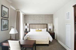 um quarto com uma cama, uma secretária, uma mesa e uma cadeira. em Marriott Syracuse Downtown em Syracuse