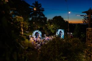 a group of people standing in a garden at night at MC Mountain Home in Tagaytay