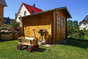 una piccola casa in legno con un grill sull'erba di Holiday House Nightingale Glowe a Glowe