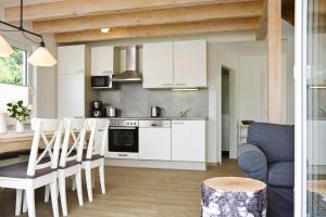 a kitchen with white cabinets and a table and chairs at Holiday homes by the lake in the Geesthof holiday park Hechthausen in Hechthausen