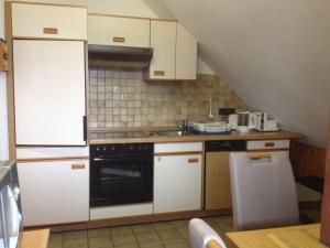 a kitchen with white cabinets and a black oven at Holiday apartment Schupp in Wittenschwand