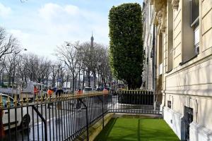 a view of a street with a building and green grass at Elegant studio avenue Montaigne in Paris