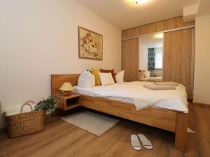 - une chambre avec un grand lit et un miroir dans l'établissement Apartment in Ostseebad Ahrenshoop, à Wustrow
