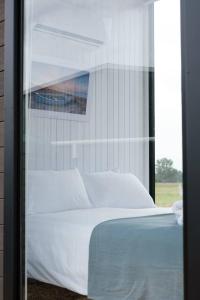 1 dormitorio con cama blanca y ventana en Starry Night Farmstay, en Forbes