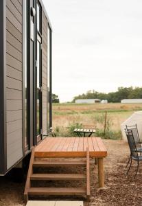 un porche de una casa con mesa y sillas en Starry Night Farmstay, en Forbes