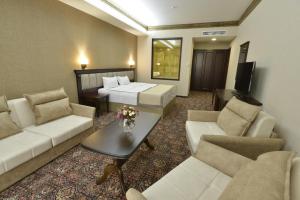 een hotelkamer met een bank, een bed en een tafel bij Konyak Hotel in Jerevan