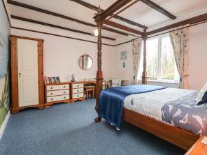 a bedroom with a bed and a desk and a window at Lighthouse in Penzance