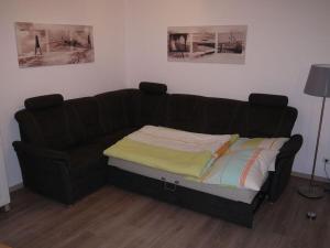 ein schwarzes Sofa mit einem Bett in einem Zimmer in der Unterkunft 1 in Haus Weser 1 in Cuxhaven