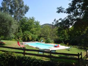 a swimming pool in a yard next to a fence at Lovely house with grass garden shared swimmingpool next to the river Ard che in Lalevade-dʼArdèche