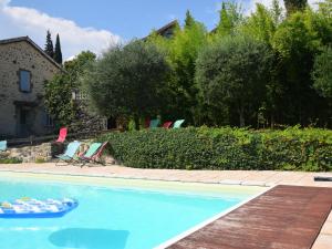 a swimming pool with two chairs and aogie board at Lovely house with grass garden shared swimmingpool next to the river Ard che in Lalevade-dʼArdèche