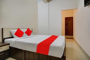 a bedroom with a large bed with red pillows at OYO Flagship Arrows Tourist Home in Cochin