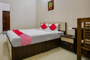 a bedroom with a large bed with red pillows at OYO Flagship Arrows Tourist Home in Cochin