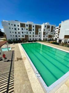 een groot zwembad voor een groot gebouw bij GIANA Stays with a pool in Mombasa