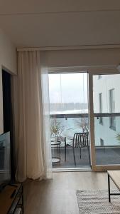 uma sala de estar com uma grande janela com vista para o oceano em Casa Emerald, laadukas kaksio saunalla, wifi, matkakeskus 280 m, juna ja bussiasema em Kajaani