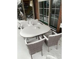 a table and chairs on a patio in the snow at Pleasant apartment in Münster in Münster +13 photos