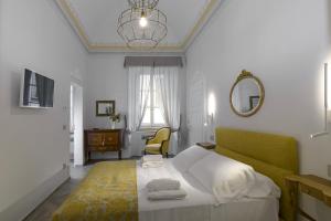 a bedroom with a bed and a mirror and a chair at La Casa del Poeta in Colle Val D'Elsa