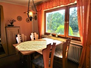 einen Esstisch mit Stühlen und ein Fenster in der Unterkunft Holiday apartment Anita Wald in Bad Münstereifel