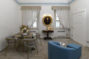 a living room with a table and a blue chair at La Casa del Poeta in Colle Val D'Elsa