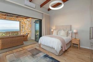 a bedroom with a bed and a large window at Waterstone Villa in Hermanus