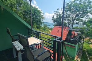 un balcón con 2 sillas y una mesa y una casa en Plankton Bungalow and Camping en Koh Rong Island