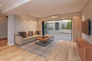a living room with a couch and a table at Waterstone Villa in Hermanus