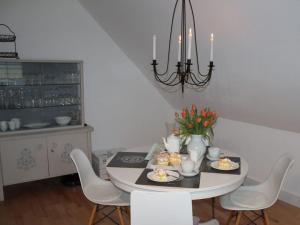 tavolo da pranzo con sedie bianche e lampadario pendente di Holiday apartment in the tower a Oberfell