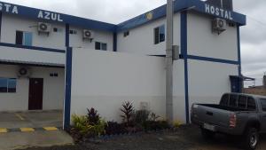 een vrachtwagen geparkeerd voor een ziekenhuisgebouw bij Hostal Costa Azul in Manta