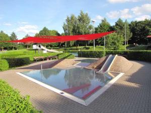 una fontana in un parco con una tettoia rossa di Lively apartment in Mönchsroth 