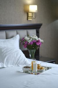 een dienblad met eten op een bed met een bord met eten bij Konyak Hotel in Jerevan