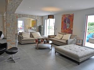 een woonkamer met banken en een stenen muur bij Magnificent Villa in Saint Ambroix with Private Pool in Saint-Ambroix
