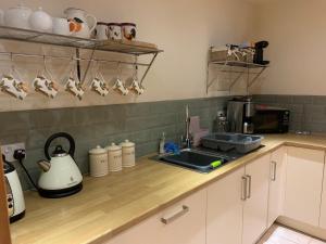 encimera de cocina con fregadero y cafetera en Drimnatorran Farm Lodge, en Estroncia