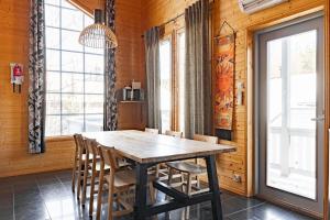uma sala de jantar com uma mesa de madeira e cadeiras em Himos Villa Jimi Hendrix, Ei lisäkuluja! em Jämsä