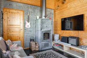 a living room with a stone fireplace and a tv at Himos Villa Jimi Hendrix, Ei lisäkuluja! in Jämsä